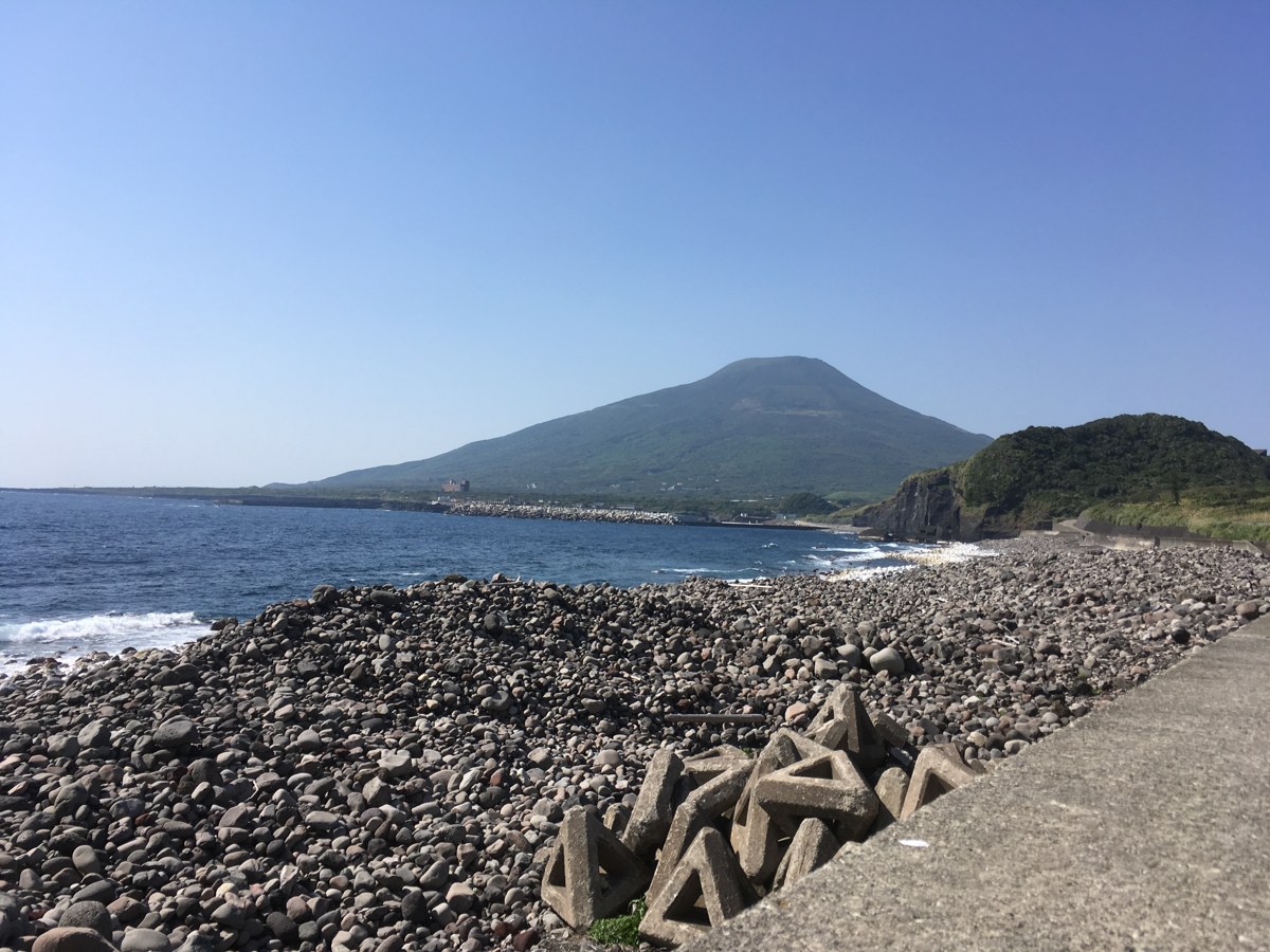 黒い丸石の海岸と沖に浮かぶ八丈小島