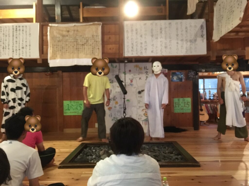 桃岩荘のミーティングで歌うヘルパーさんと壁の時刻表示