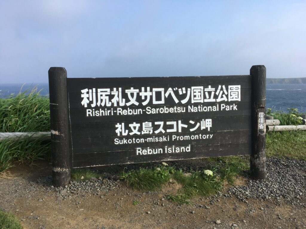 礼文島スコトン岬の案内看板。背後に利尻礼文サロベツ国立公園の海が広がる
