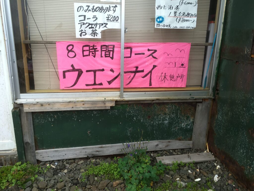 宇遠内(ウエンナイ)休憩所の窓に貼られた「8時間コース」の案内と飲み物メニュー