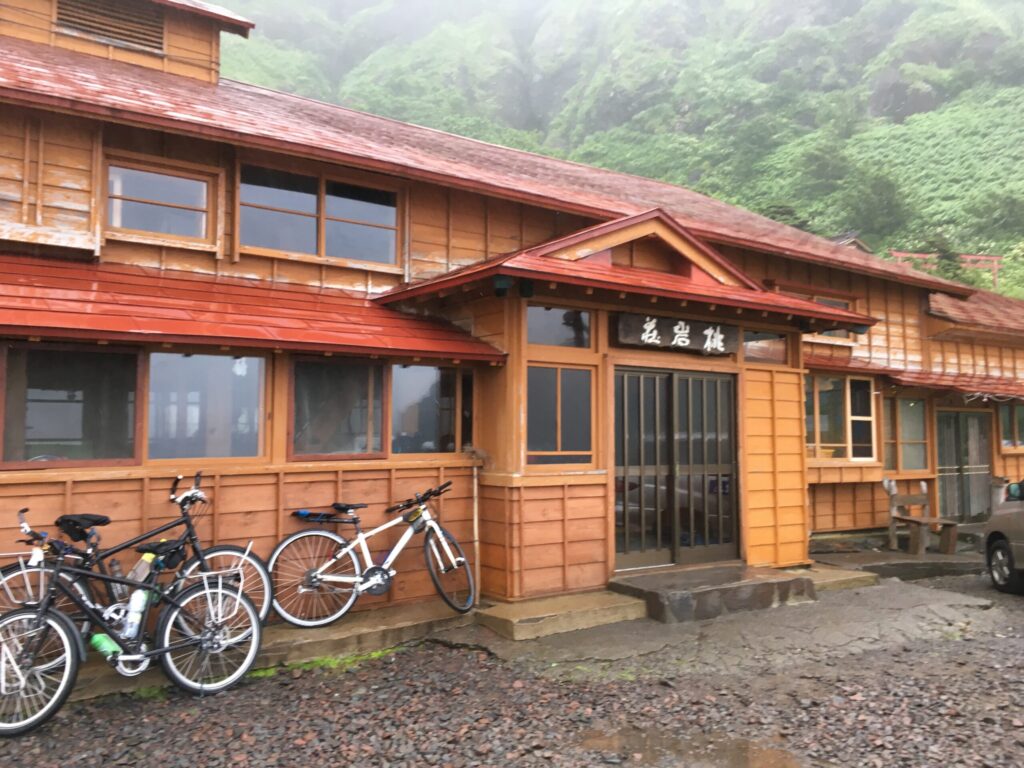 礼文島の桃岩荘ユースホステルの木造の建物と玄関の看板