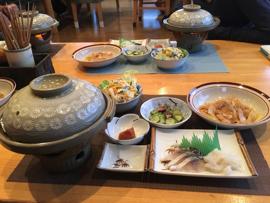 星観荘の手料理。鍋と小鉢、お刺身が並ぶ食卓
