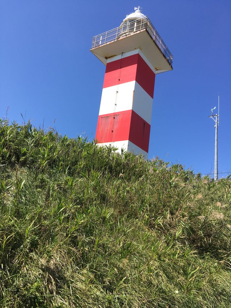 青苗岬灯台|青空に立つ赤白の縞模様の灯台。奥尻島の南端
