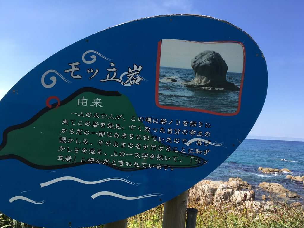 モッ立岩の由来を書いた青い案内板|奥尻島