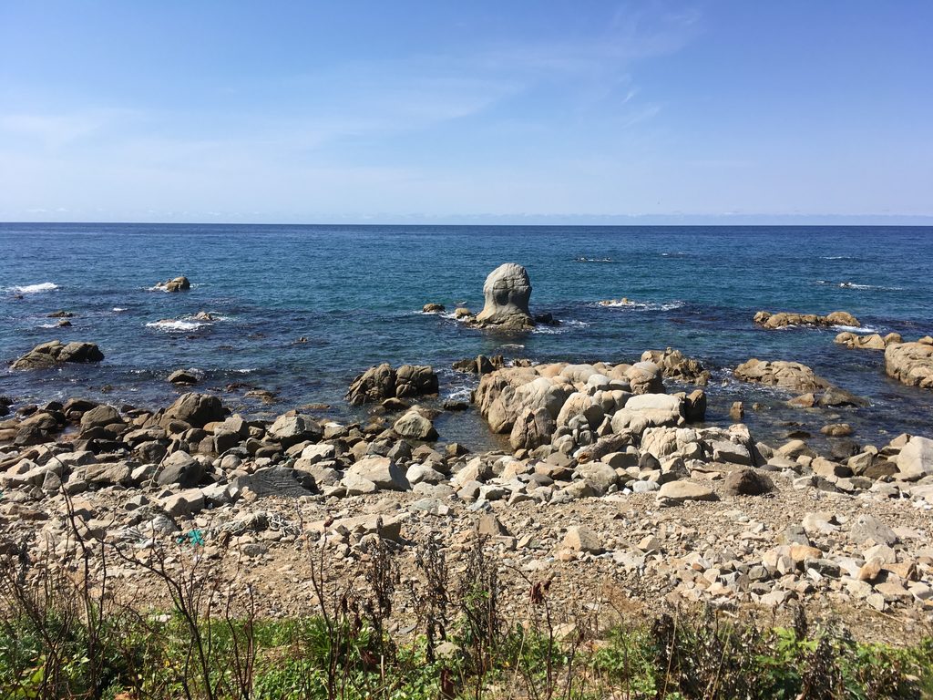 モッ立岩|岩場の海に立つ、人の頭のような形をした岩|奥尻島