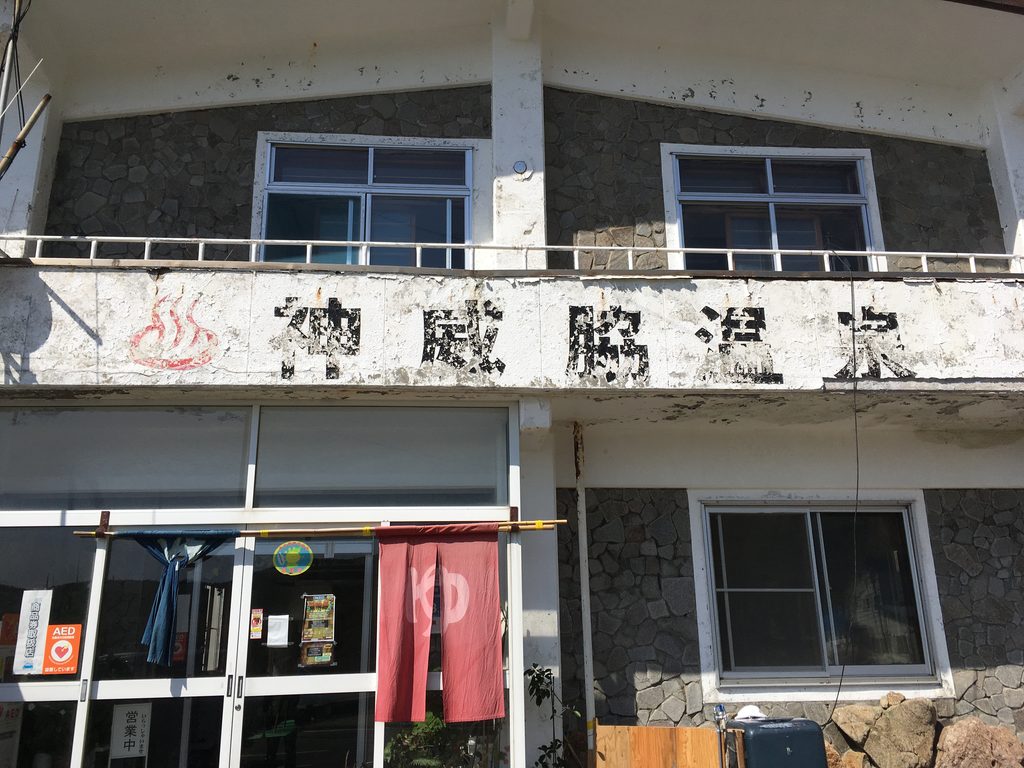 神威脇温泉の外観(2階建ての建物と赤いのれん)|奥尻島