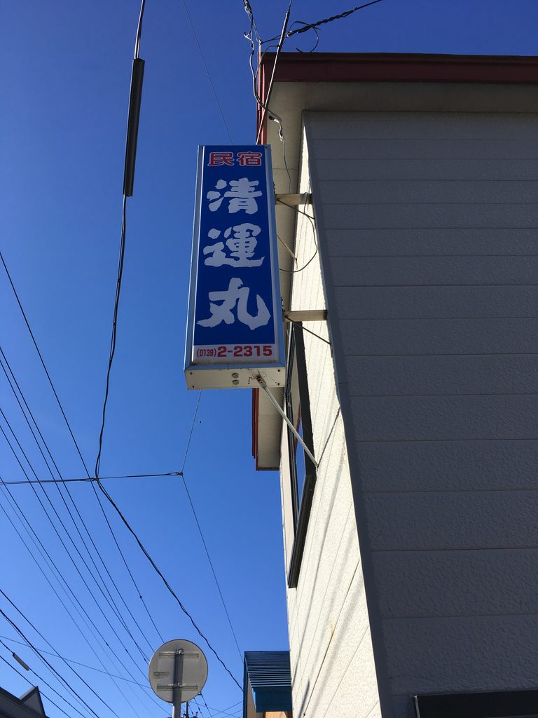民宿清運丸の青い縦看板。白い文字で「民宿 清運丸」と書かれている