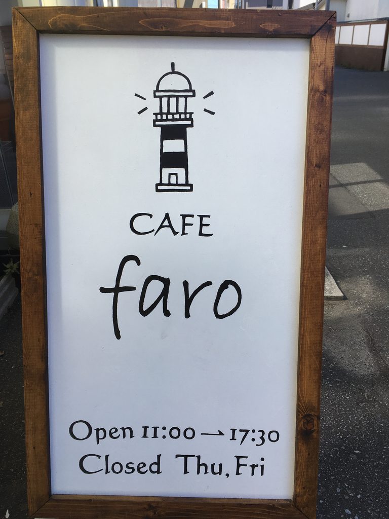 奥尻島のカフェfaroの看板。灯台のイラストと「Open 11:00→17:30 Closed Thu,Fri」の文字