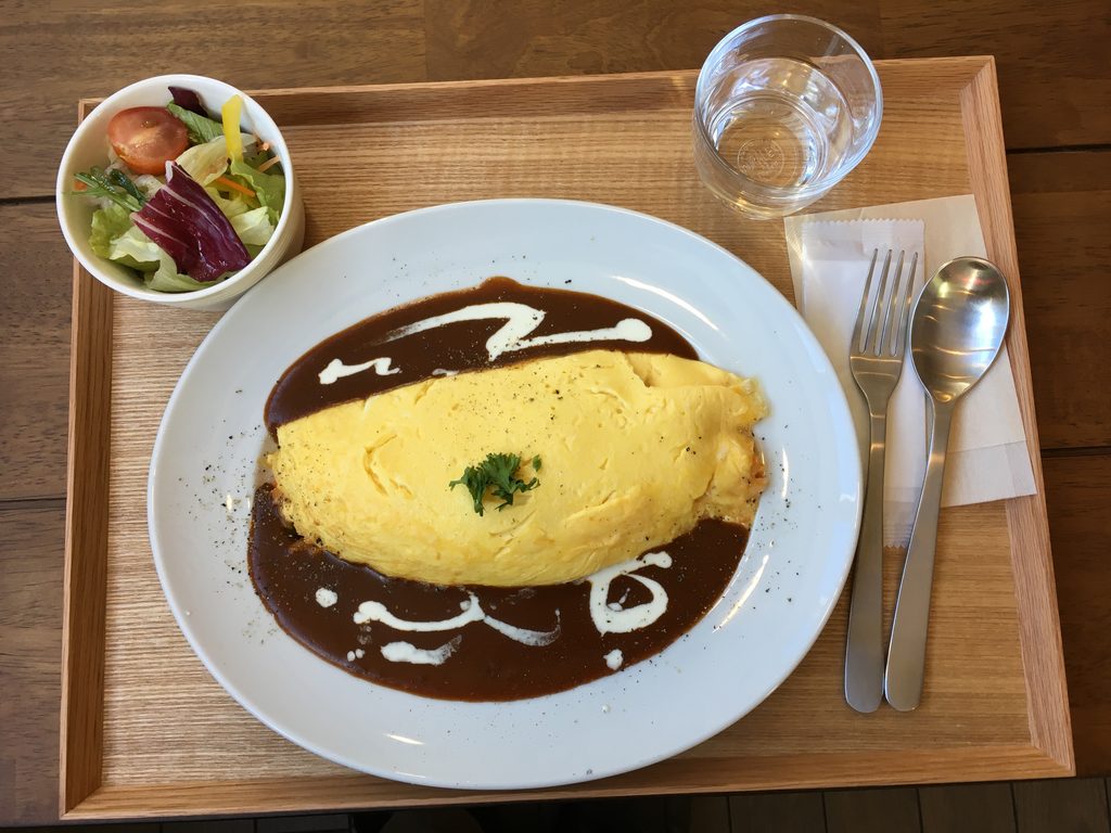 カフェfaroのオムライス。デミグラスソースがかかり、サラダとセットで木のトレイにのっている