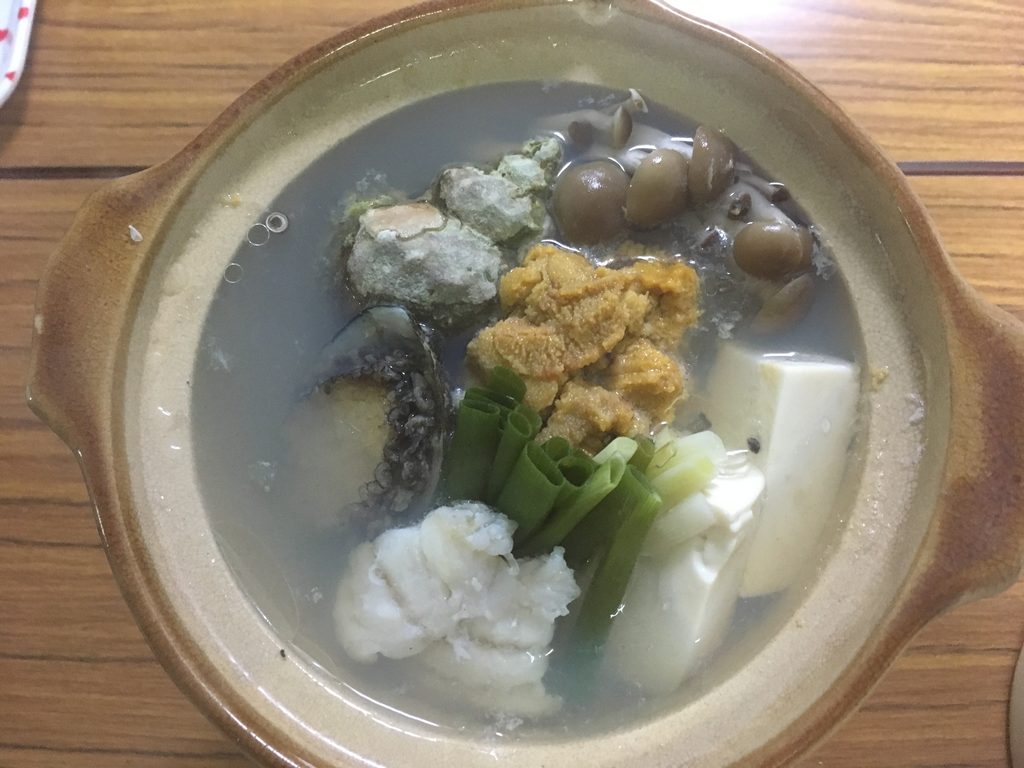 民宿カサイの夕食に出たウニとアワビの小鍋。豆腐、ねぎ、しめじと一緒に煮込まれている