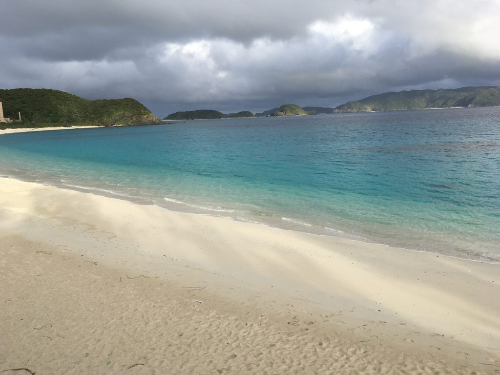 古座間味ビーチの波打ち際と、遠くの島々